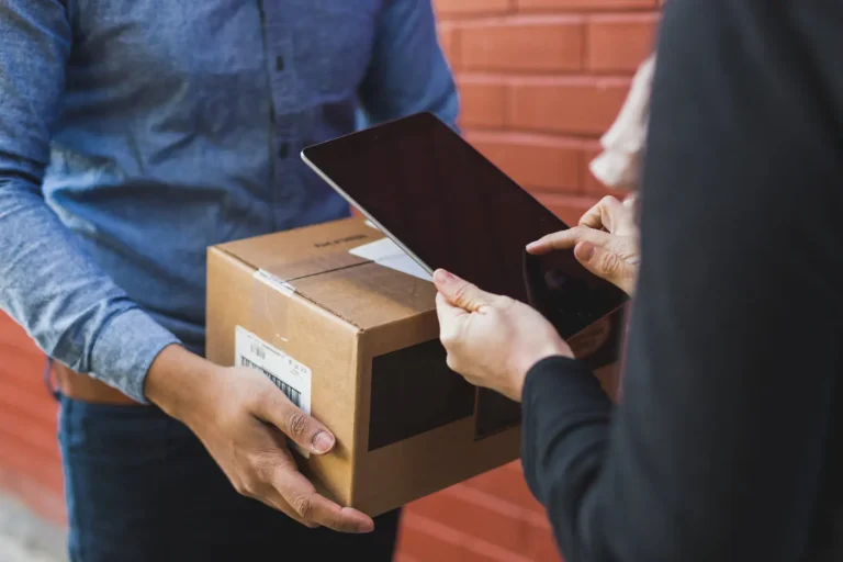 Courier confirming a parcel delivery on a tablet