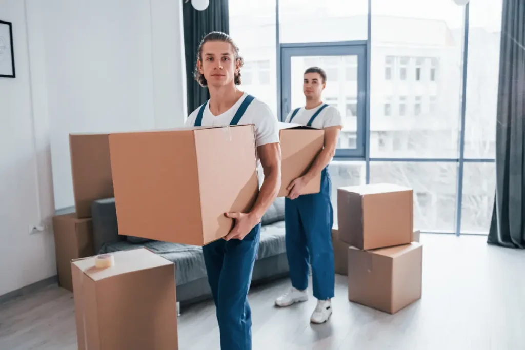 Movers carrying boxes in a bright apartment