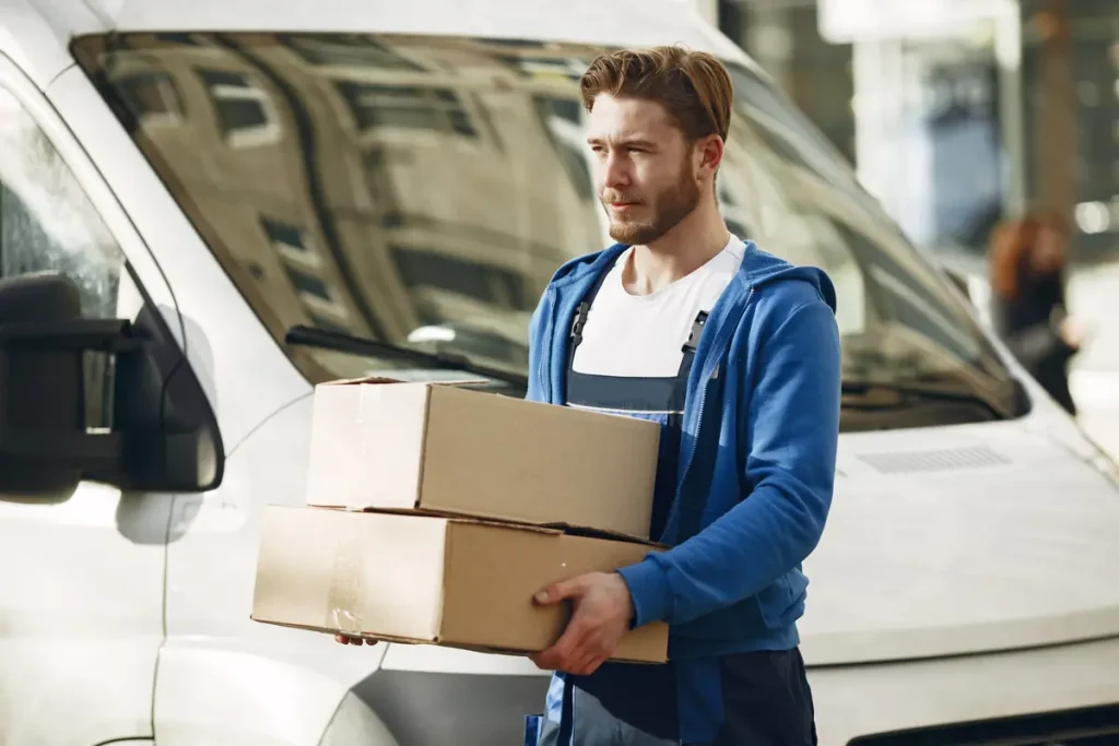 Courier carrying boxes from a white cargo van for same-day delivery